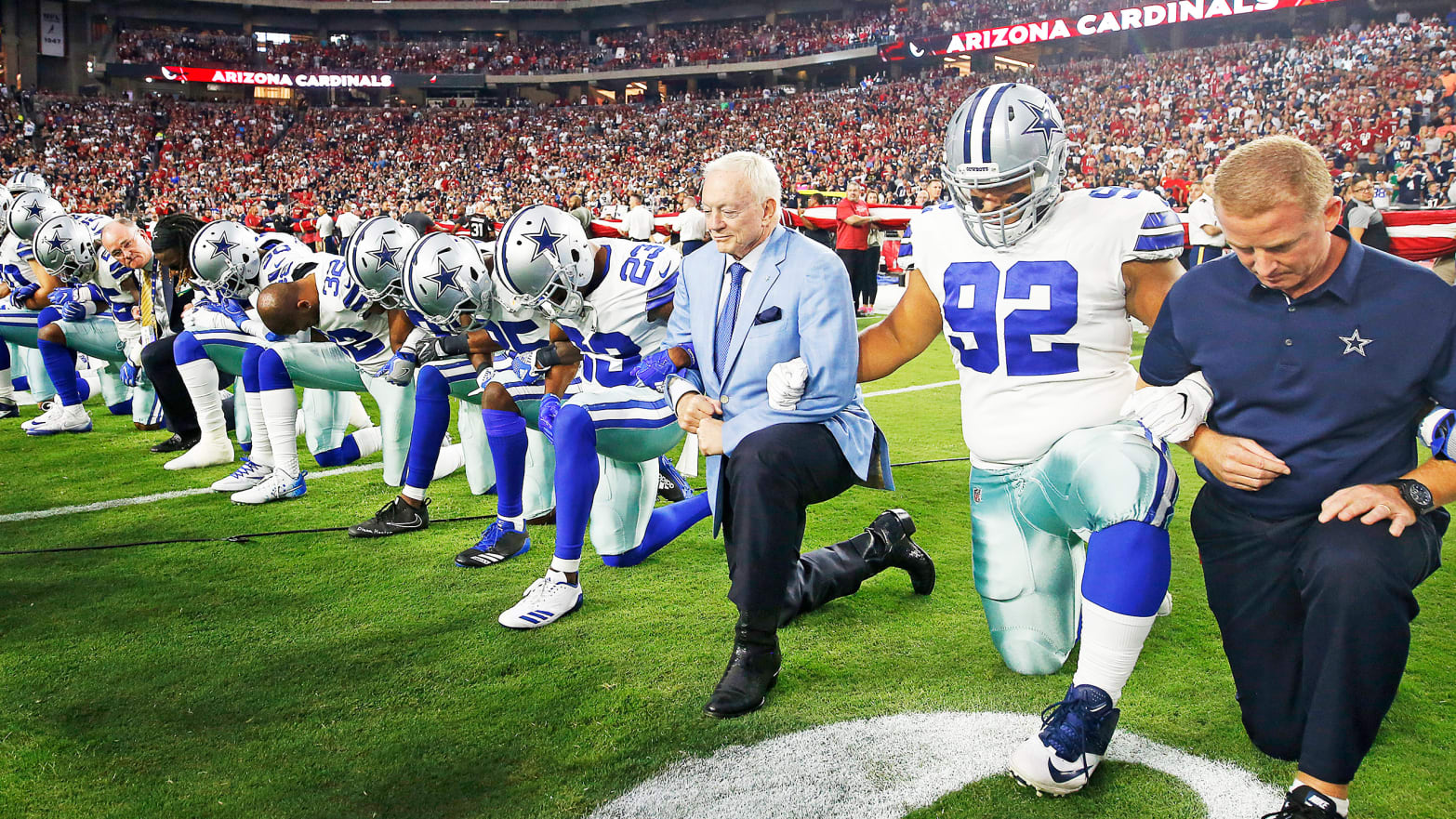Dallas Cowboys owner Jerry Jones and head coach Jason Garrett kneel with their team