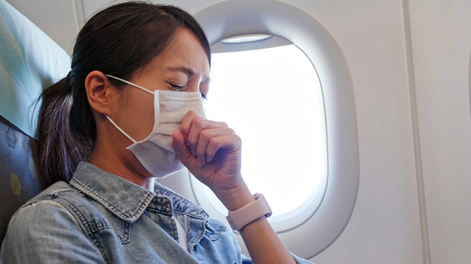 photo of woman sneezing with mask on face airplane thanksgiving will i get sick flu influenza shot vaccine flight holiday travel immunity immune system robin thompson