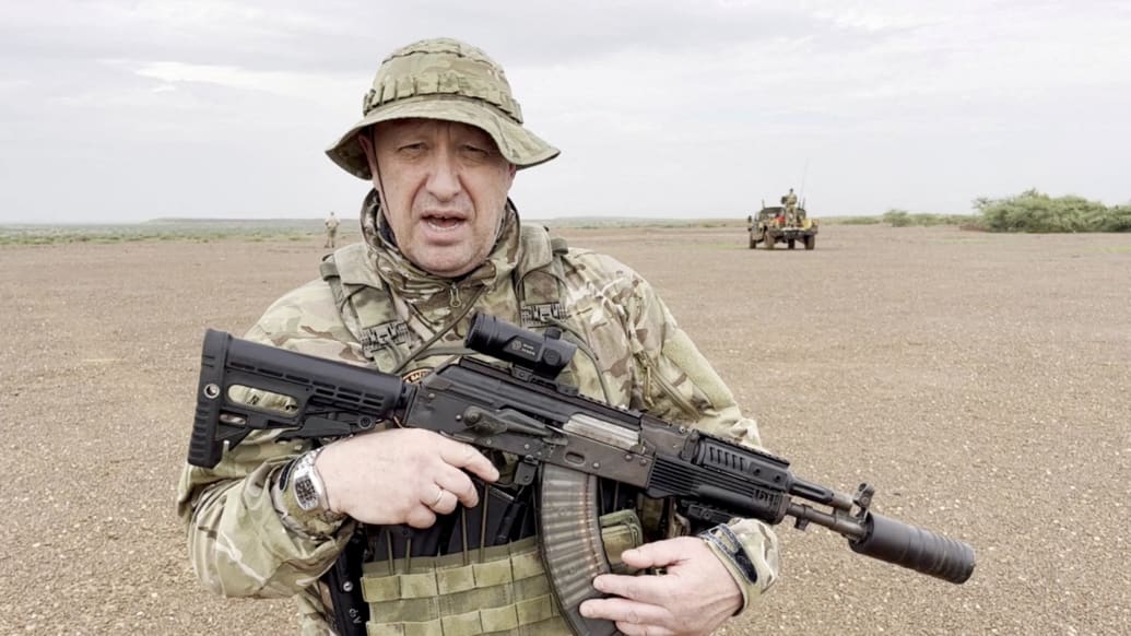 Yevgeny Prigozhin gives an address in camouflage and with a weapon in his hands in a desert area at an unknown location, in this still image taken from video possibly shot in Africa and published August 21, 2023.