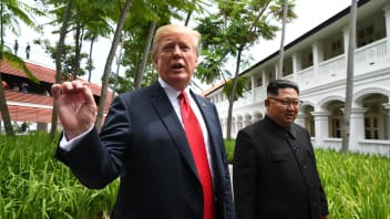US President Donald Trump (L) speaks to the media as he walks with North Korea's leader Kim Jong Un (R) during a break in talks at their historic US-North Korea summit, at the Capella Hotel on Sentosa island in Singapore on June 12, 2018.