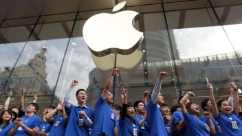 Apple Inc. employees pump their fists in the air as they open the company’s new store in Shanghai, China, on Friday, Sept. 23, 2011.