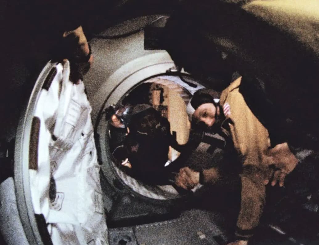 Tom Stafford shakes the hand of a Soviet cosmonaut in space.