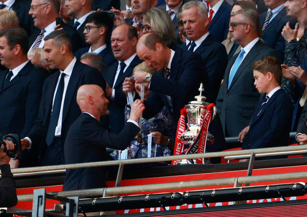 Manchester United manager Erik ten Hag collects his winners medal from Britain's Prince William, Prince of Wales as Prince George looks on.