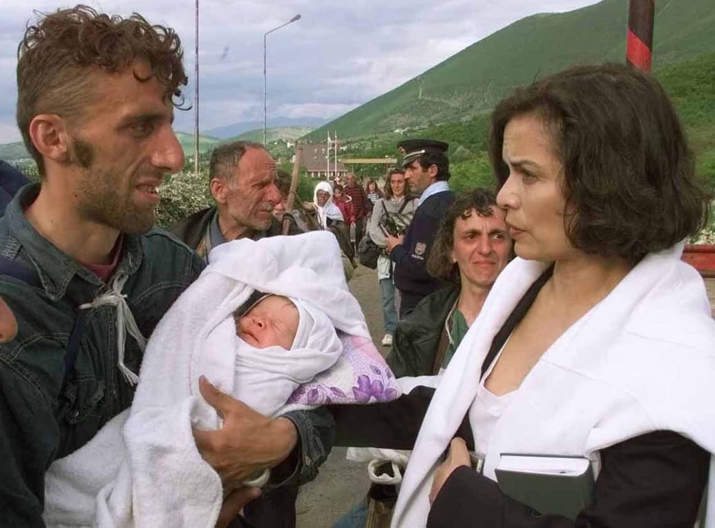 Bianca Jagger with ethnic Albanian refugees from Kosovo at the Morina border crossing where several thousand refugees fled.