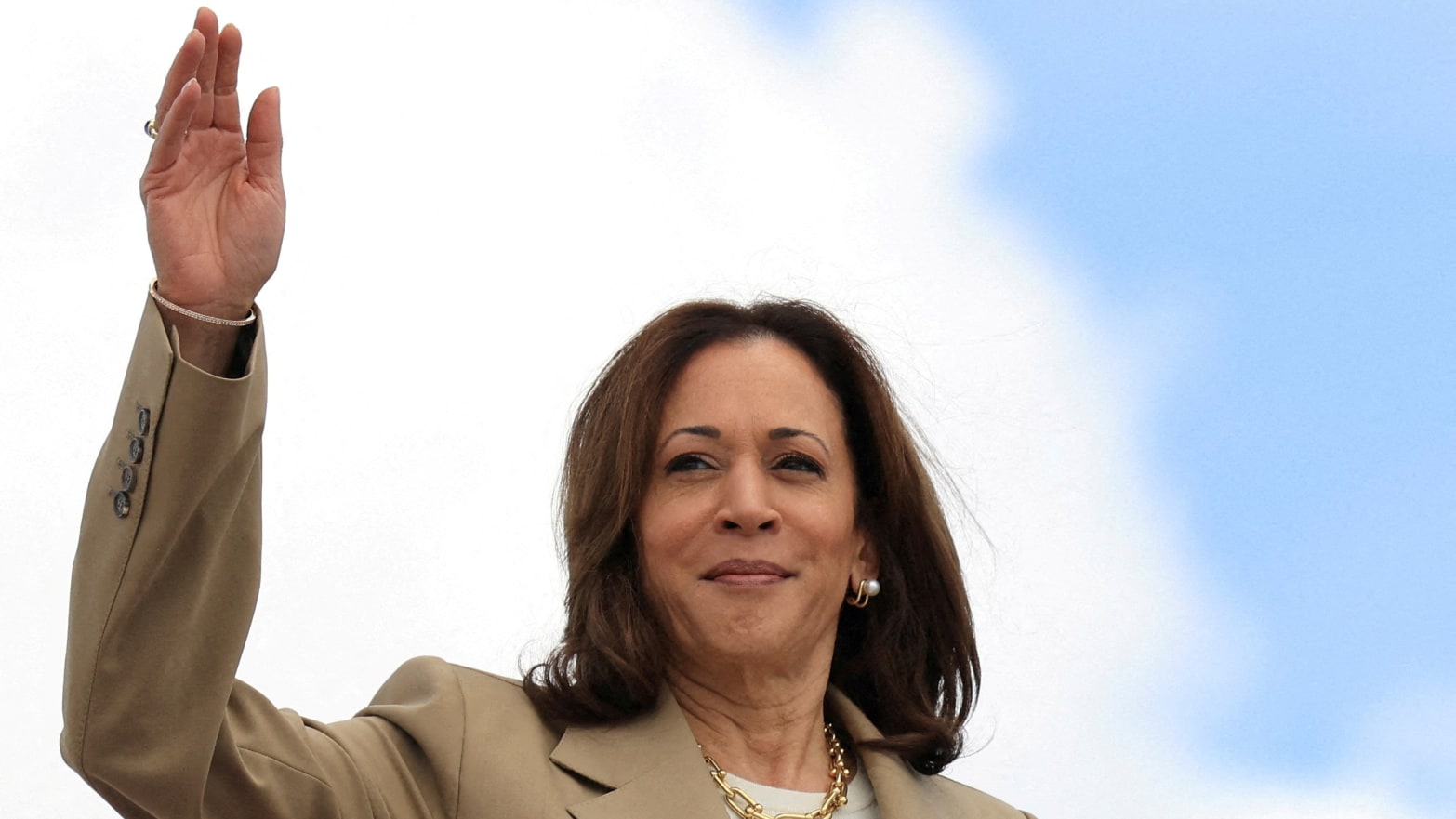 Kamala Harris waves while exiting a plane.