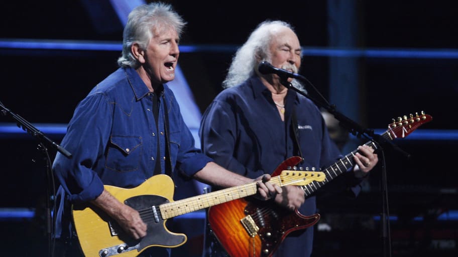 Graham Nash and David Crosby sing and play guitars as they perform.
