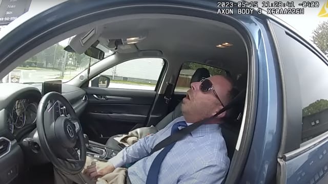 A still frame from police bodycam footage showing former Cranston, Rhode Island city councilman Matthew Reilly passed out in his car.