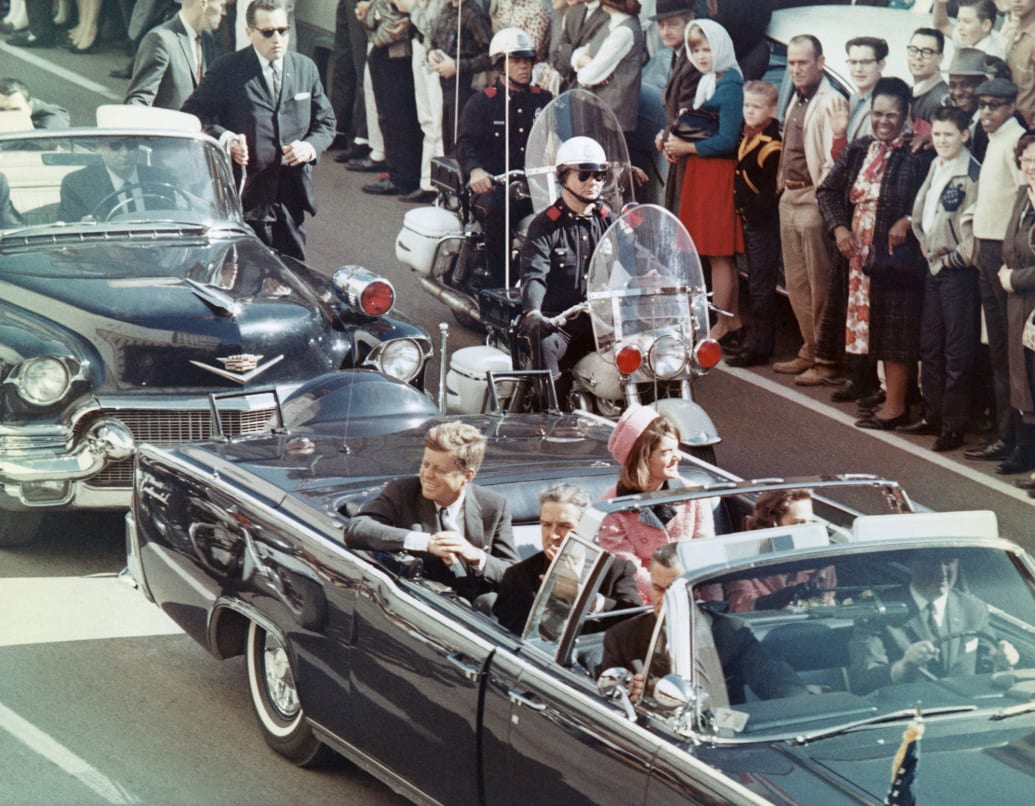President John F. Kennedy, First Lady Jacqueline Kennedy, Texas Governor John Connally, smile at the crowds lining their motorcade route in Dallas.