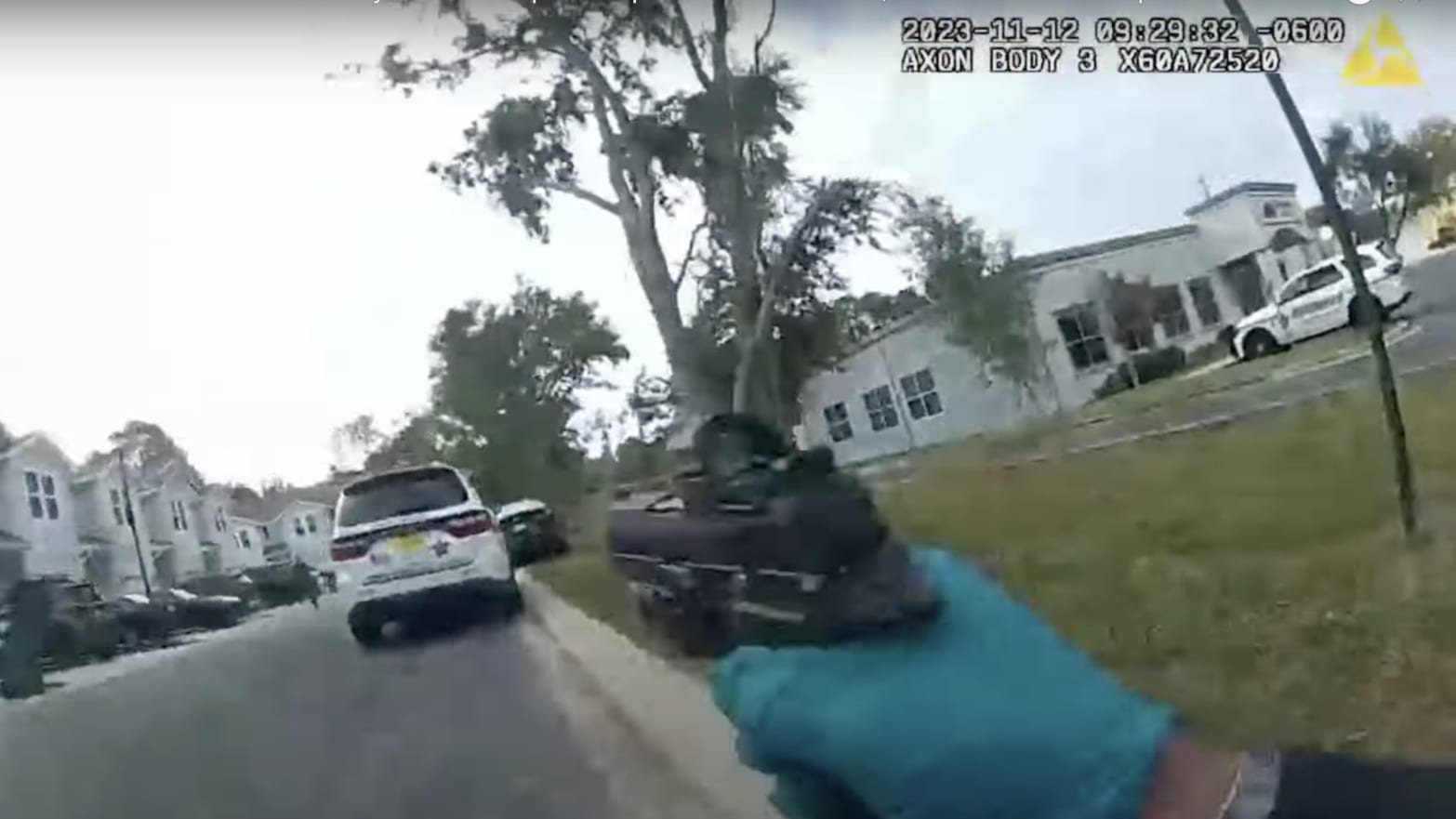 Screengrab from body-camera footage showing an officer with his gun drawn in the direction of his patrol vehicle.