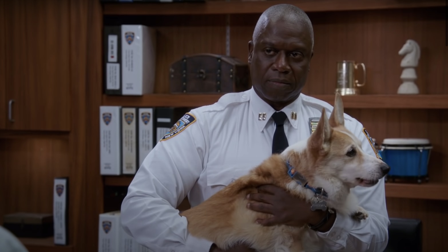 Andre Braugher as Captain Holt in Brooklyn Nine-Nine, holding Cheddar the dog.