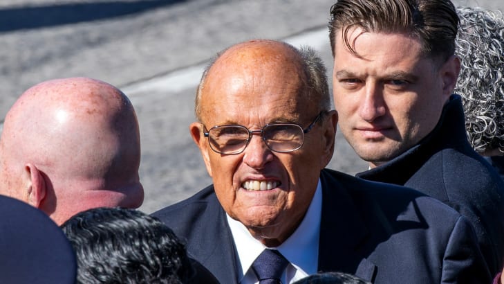 Rudy Giuliani makes a face while attending a funeral.