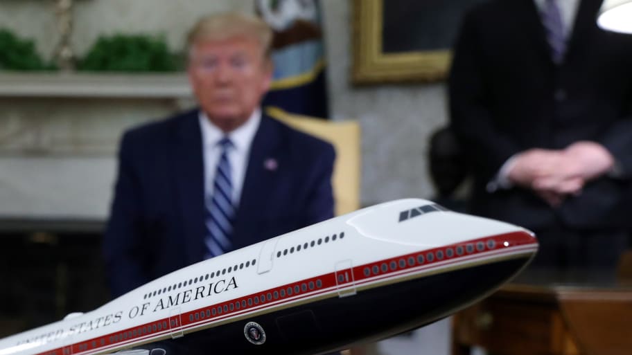 Trump out of focus behind a model of Air Force One in red white and blue livery