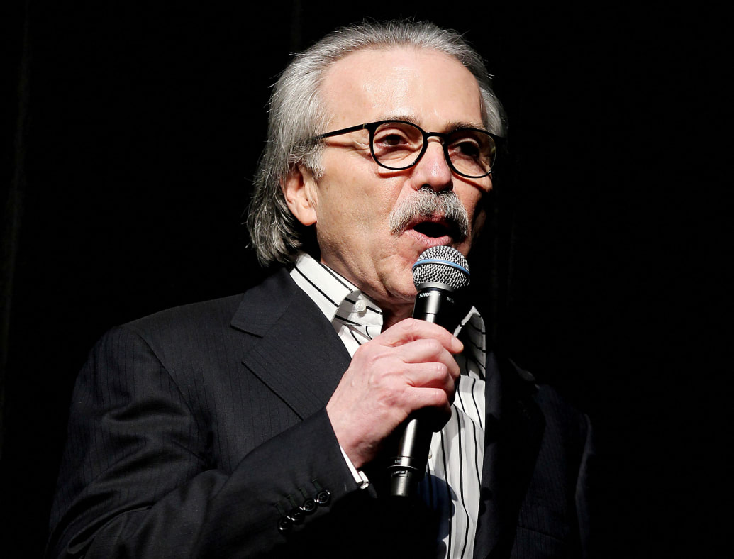 David Pecker holds a microphone while speaking on stage.