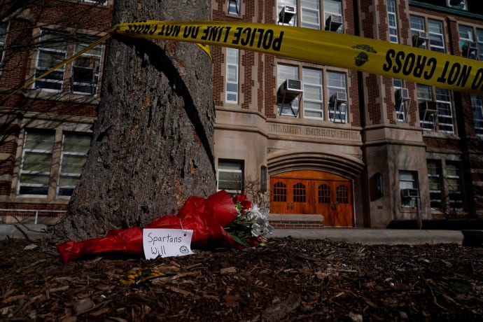 A bouquet rests by police tape surrounding Berkey Hall following a shooting on the Michigan State University campus in East Lansing.