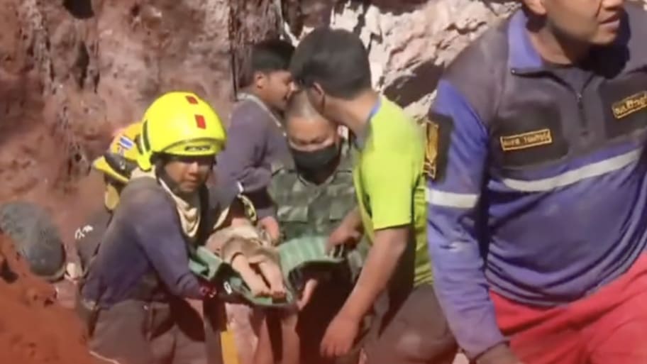 Rescue workers carry a baby after retrieving her from a well in Thailand. 