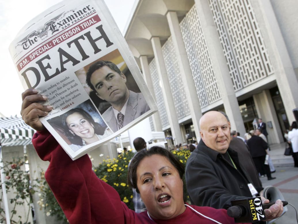 A newspaper carrier for the San Francisco Examiner holds a special-edition newspaper after Scott Peterson was sentenced to death.
