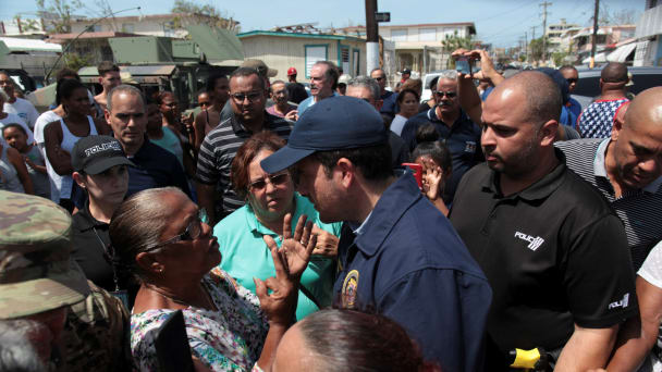 Puerto Rico's Governor Ricardo Rossello talks to a woman during a distribution of relief item