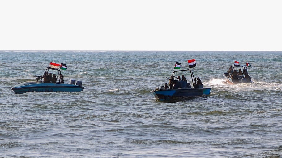Members of the Yemeni Coast Guard affiliated with the Houthi group patrol the sea with Yemeni and Palestinian flags flying from their boats.