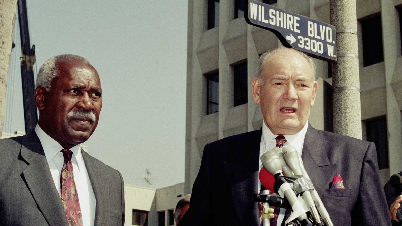 Los Angeles Politician Nate Holden (L) listens to Los Angeles City Council Member John Ferraro