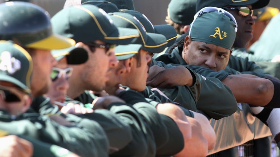 Oakland Athletics' Manny Ramirez (R) of the Dominican Republic chats with teammates before the start of their first spring training game at Phoenix Municipal stadium in Phoenix, Arizona.