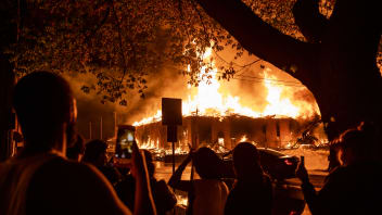 People look on as a construction site burns in a large fire near the Third Police Precinct on May 27, 2020 in Minneapolis, Minnesota. A number of businesses and homes were damaged as the area has become the site of an ongoing protest after the police killing of George Floyd. Four Minneapolis police officers have been fired after a video taken by a bystander was posted on social media showing Floyd's neck being pinned to the ground by an officer as he repeatedly said, "I can’t breathe". Floyd was later pronounced dead while in police custody after being transported to Hennepin County Medical Center.