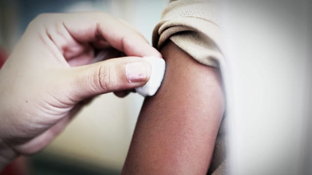 image of child getting a shot with bandage over arm afm acute flaccid myelitis polio like minnesota cdc enterovirus d68 mysterious mystery disease kids children