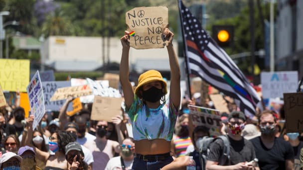 A participant holding a sign sits on a car during an All Black Lives Matter march, organized by Black LGBTQ+ leaders, in the aftermath of the death in Minneapolis police custody of George Floyd, in Hollywood, Los Angeles, California, U.S., June 14, 2020.