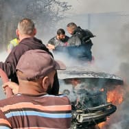 Firefighters douse a burning car after it was hit in an Israeli strike in Lebanon's southern area of Tyre.