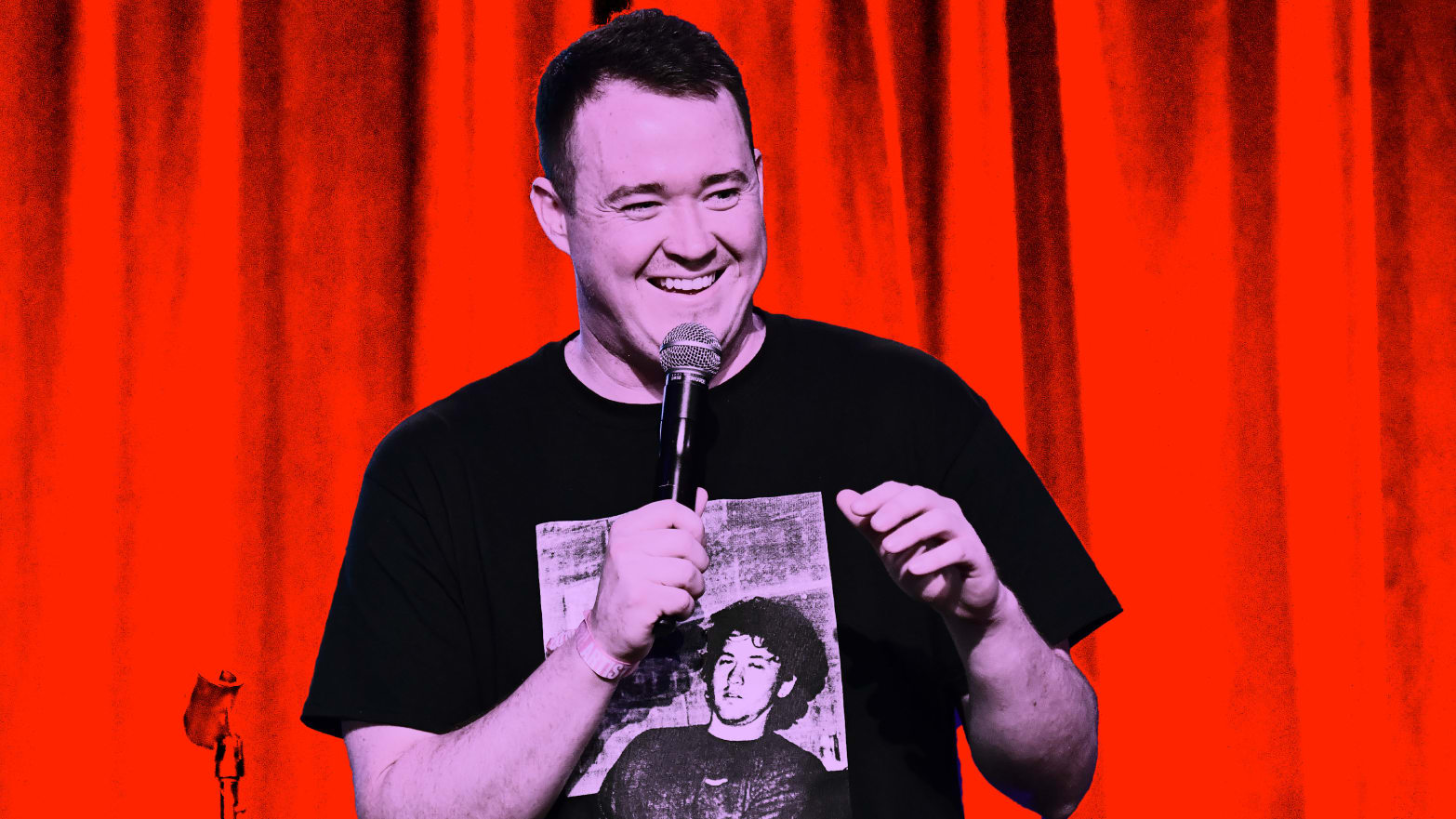Photo illustration of Shane Gillis performing standup with a red background.