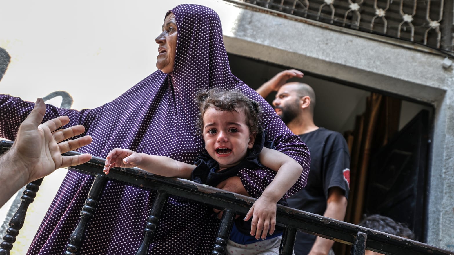 A baby cries as people leave their houses due to the Israeli airstrikes that has been going on for five days at the Sheikh Ridvan neighbourhood of Gaza City