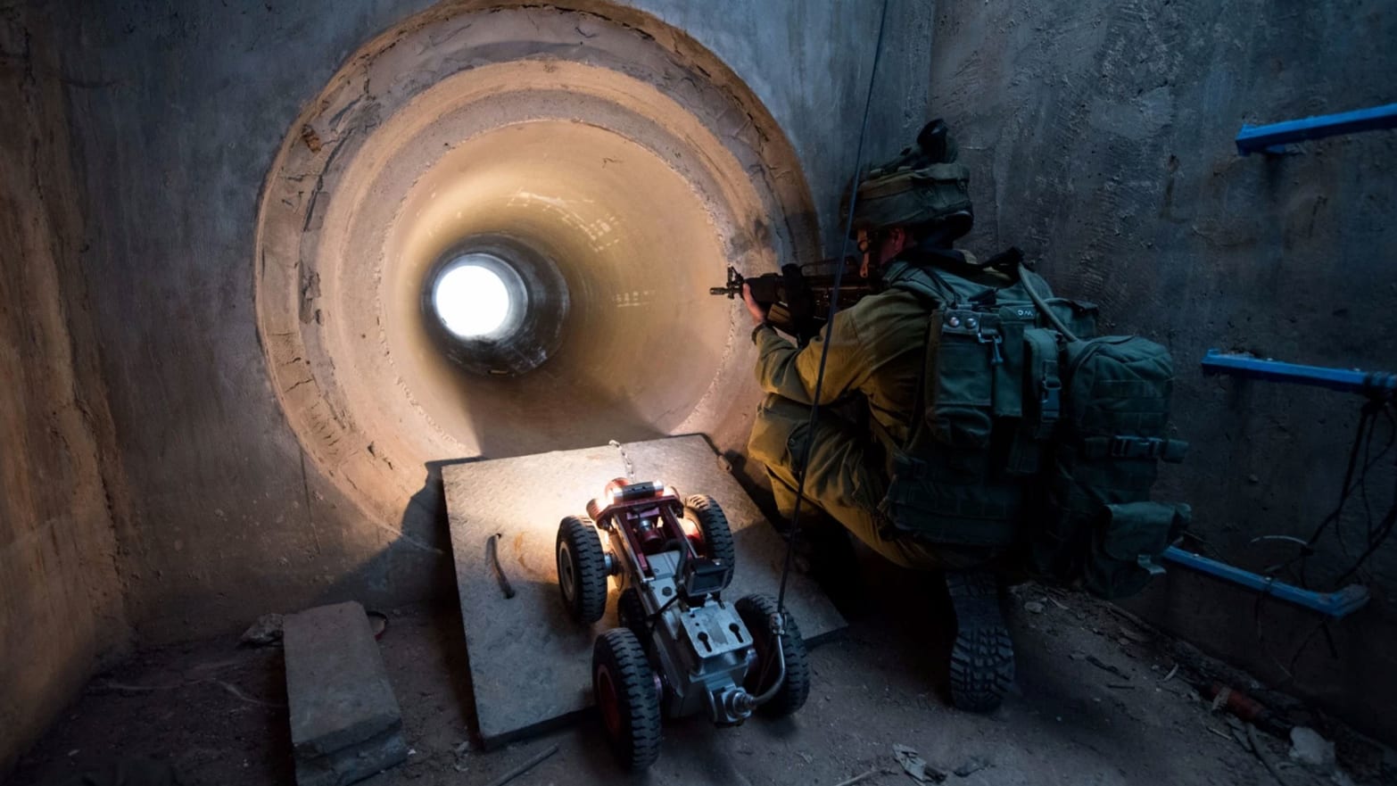An IDF soldier peers into a tunnel while a drone enters