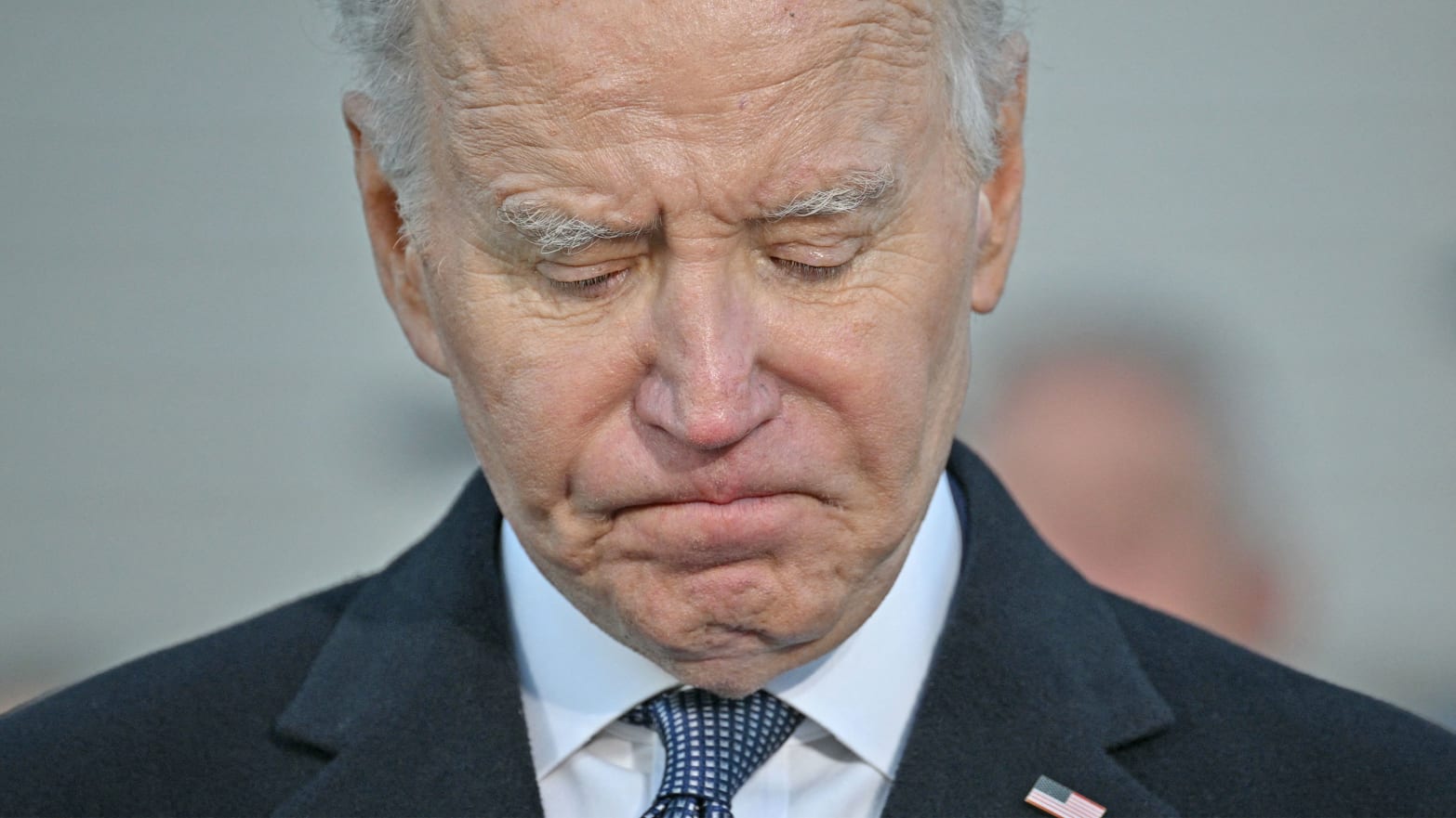 A close up photo of Joe Biden looking down and sad
