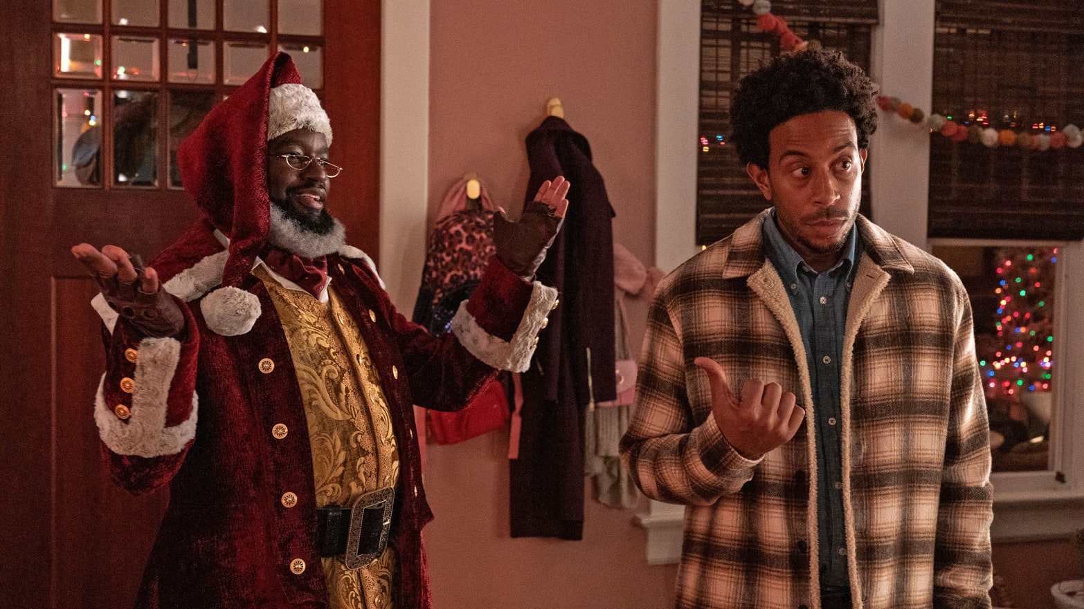 Lil Rel Howery dressed as Santa with Chris 'Ludacris' Bridges stand next to each other in a still from 'Dashing Through the Snow'