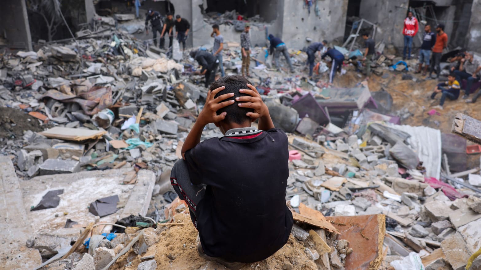 A child reacts as people salvage belongings amid the rubble of a damaged building following Israeli strikes on Rafah in southern Gaza, on Nov. 12, 2023.
