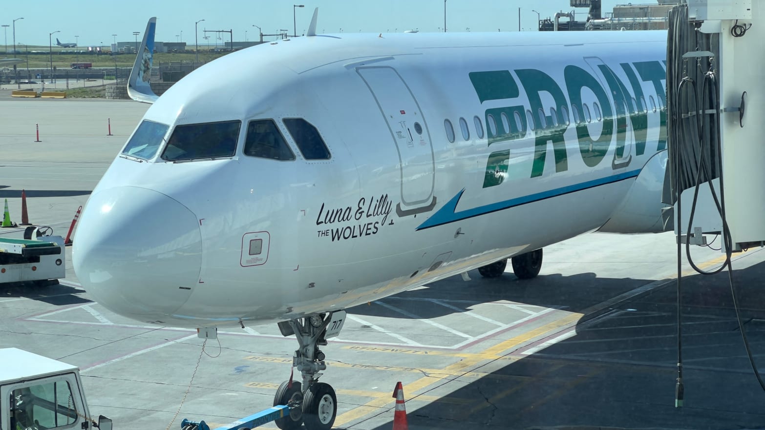 A photo of a Frontier Airlines plane parked at the gate.