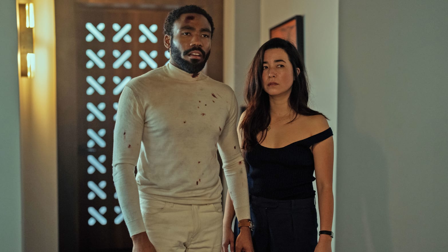 Donald Glover and Maya Erskine stand bloodied in a still from Mr. and Mrs. Smith