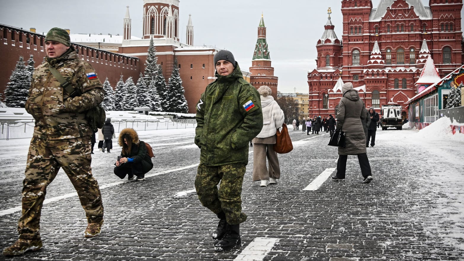 Men wearing Russian military uniforms walk along the Red square in Moscow