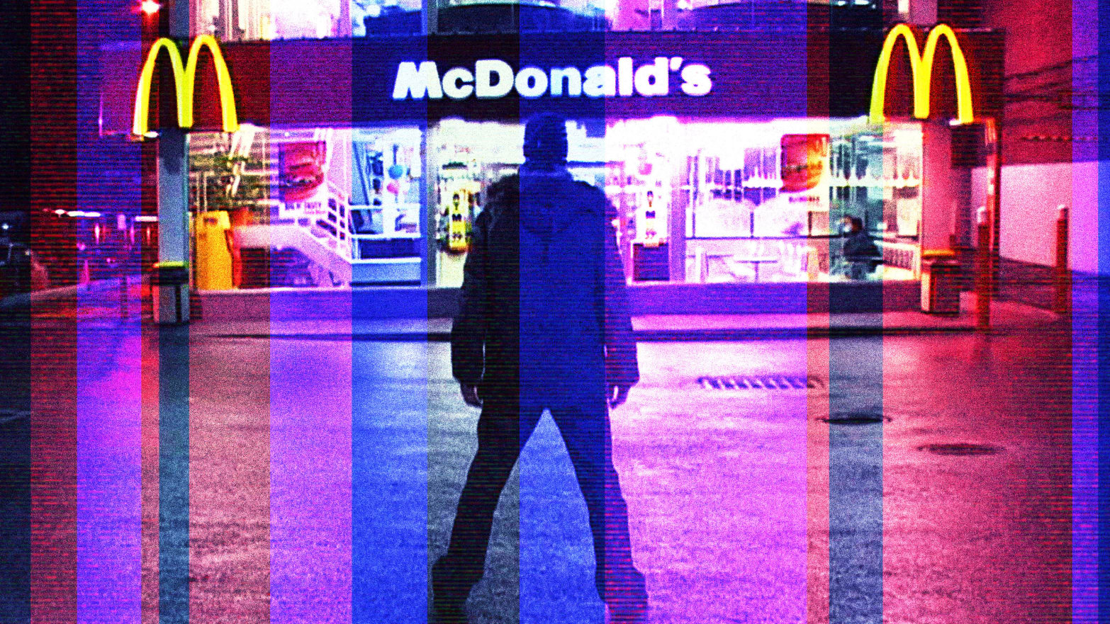 A glitched still from Morgan Spurlock’s ‘Super Size Me’ showing Morgan standing in front of a McDonald’s at night.