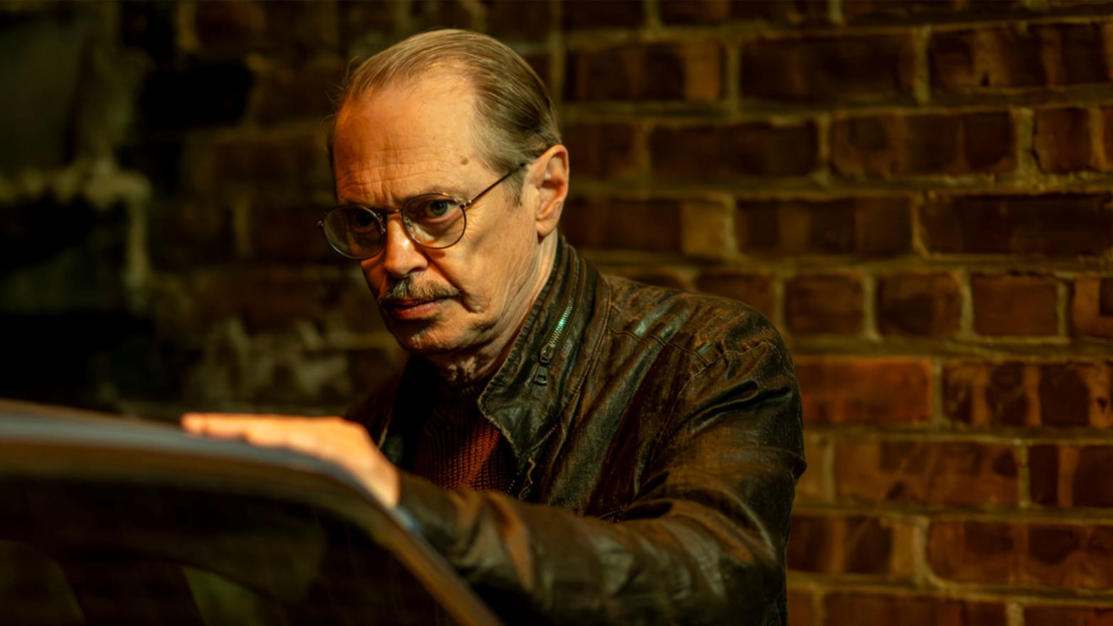 Steven Buscemi stands behind a car in a still from ‘The Shallow Tale of a Writer Who Decided to Write About a Serial Killer’