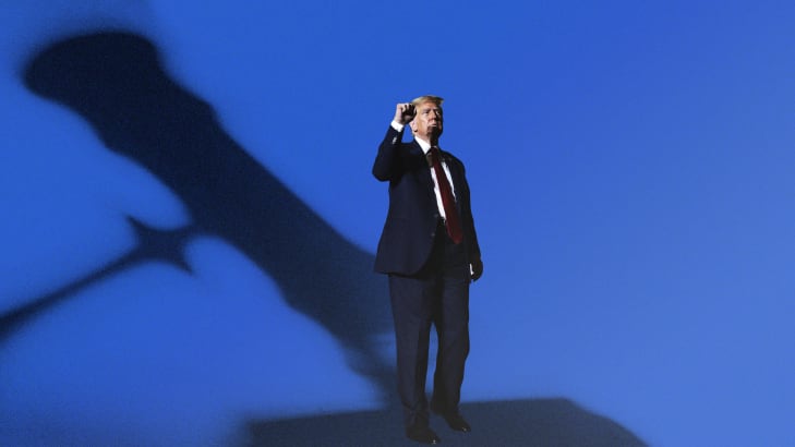 Donald Trump with a raised fist looking ahead as a giant court gavel shadow looms over him.
