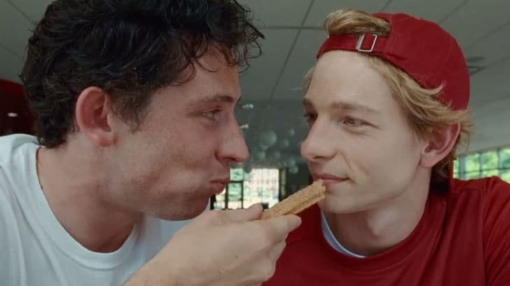 A photo still of Josh O'Connor and Mike Faist eating a churro in 'Challengers'