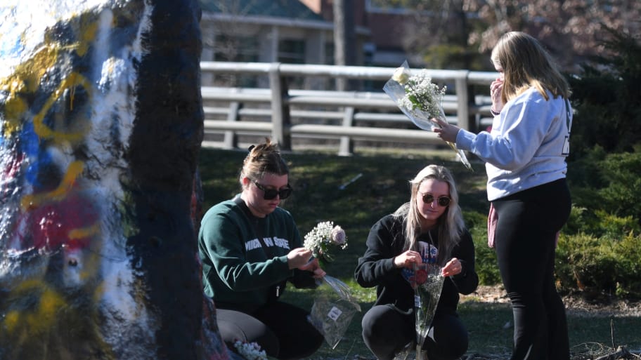 Students place flowers at a memorial for the Michigan State University shooting victims.