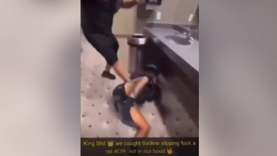 A screenshot of video showing Tekashi 6ix9ine being attacked with the caption "King Shit. we caught 6ix9ine slipping fuck a rat ADR not in our hood.”