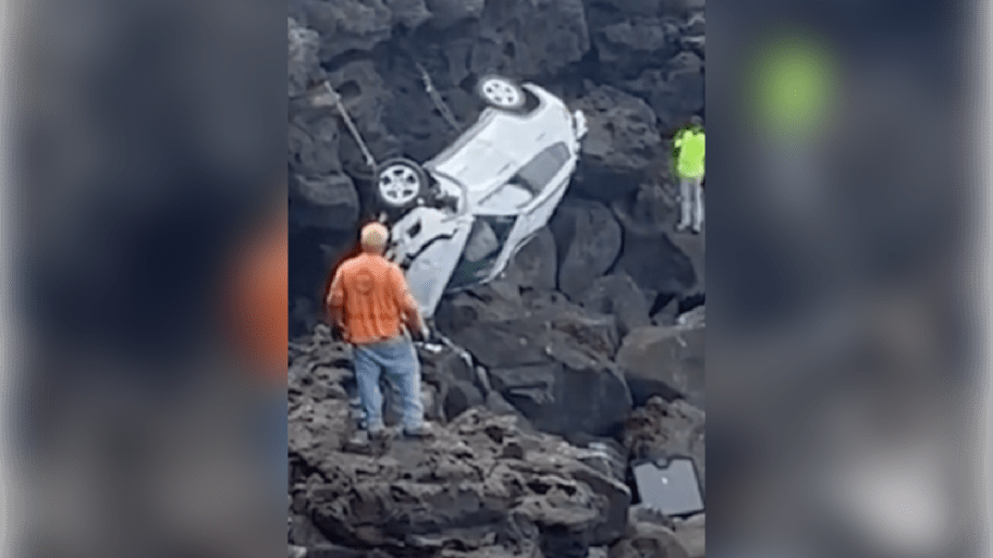 A Jeep sits atop rocks after plunging from a cliff.