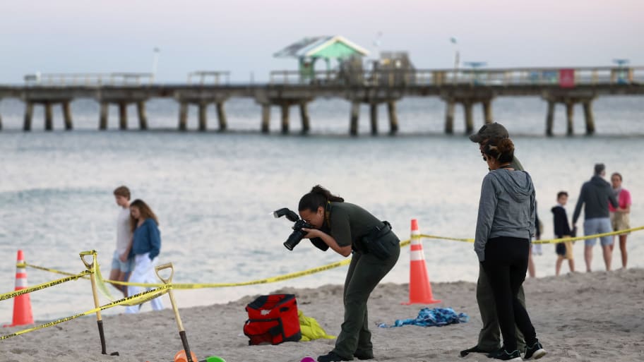 Investigators on the beach in Lauderdale-by-the-Sea take photos of the scene of a sand collapse on Tuesday, Feb. 20, 2024.