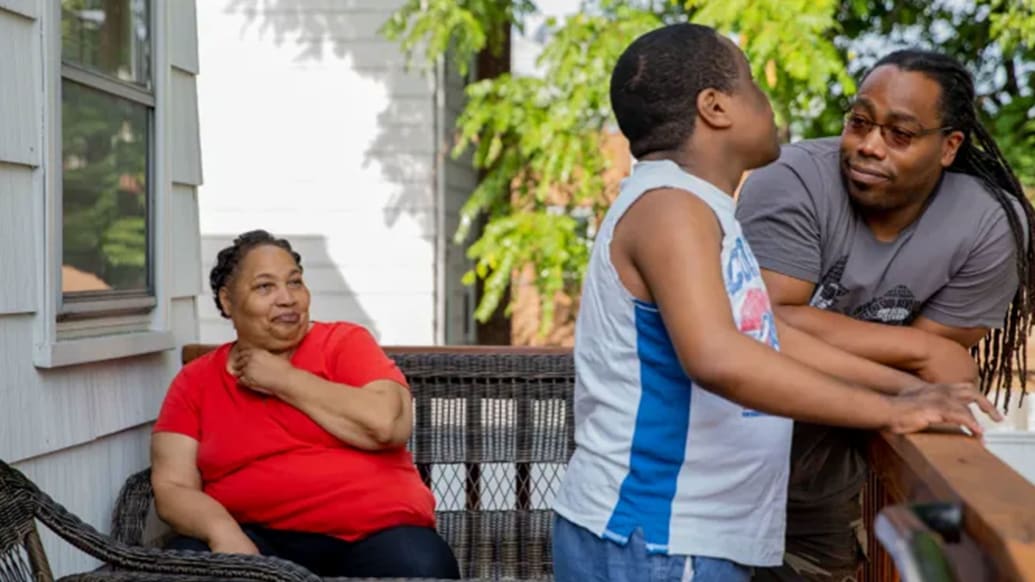 Daisy, Derrick and John Johnson stand on a porch in “Tell Them You Love Me.”