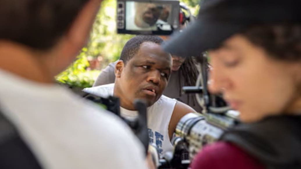 Derrick Johnson is seen through cameramen in a still from “Tell Them You Love Me.”