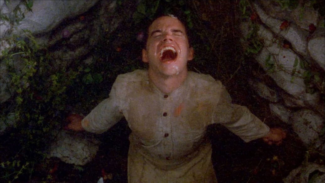 Andrew Harpending looks up while rain falls down his face in a still from 'Poison'