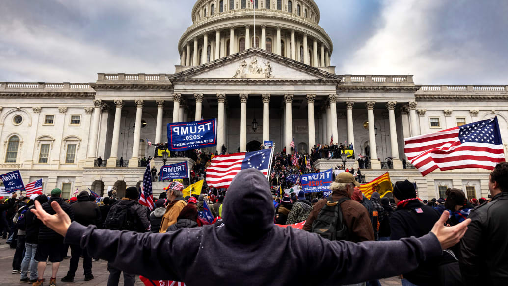 A photo including Pro-Trump protesters in front of the U.S Capitol Building.
