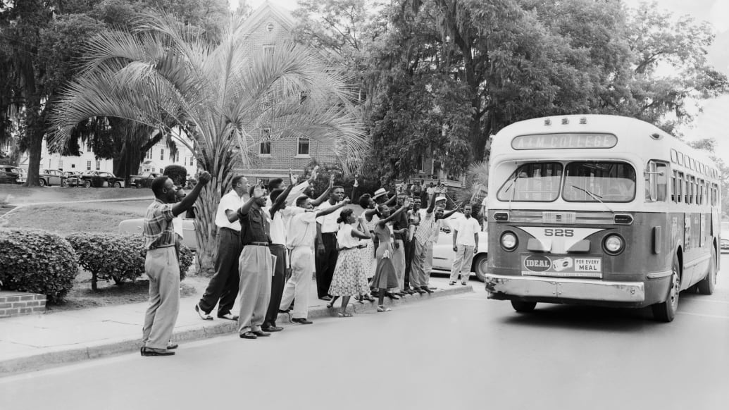African-American students at Florida A&M College wave at an empty city bus on June 1, 1956 during a protest against the racial segregation on bus lines.